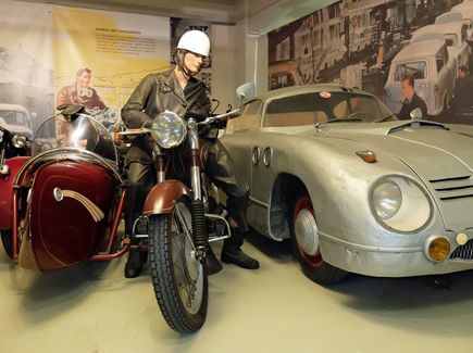 Ein Motorrad und ein alter silberner Oldtimer stehen im Museum für Sächsische Fahrzeuge in Chemnitz.