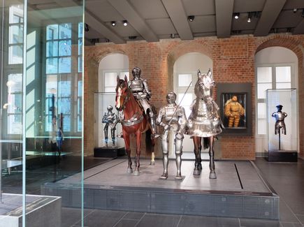 Various knights' armours on display in the Renaissance wing of Dresden's Royal Palace. In the middle of the room there are two horse figures with a knight in armour sitting on one of them and another knight standing next to his horse.