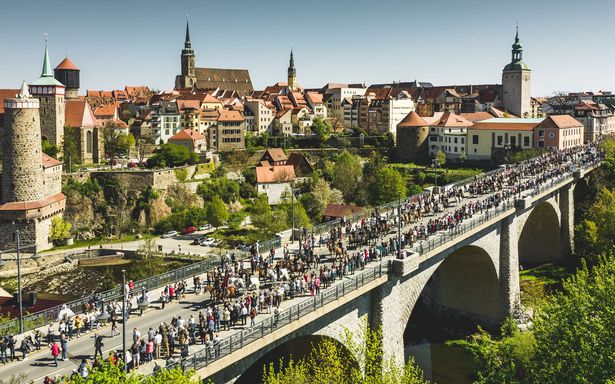 Auf einer Brücke in Bautzen sind zahlreiche Osterreiter unterwegs. Der sorbische Brauch wird von vielen Zuschauern begleitet. 