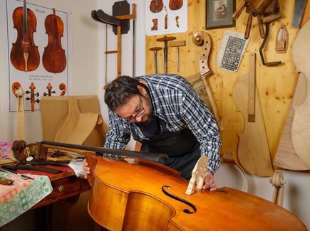 A musical instrument maker at work in his workshop. 