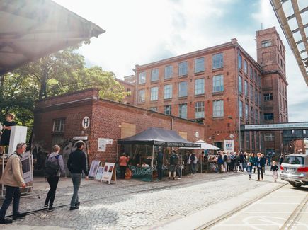 Menschen vor dem Außengebäude der Spinnerei